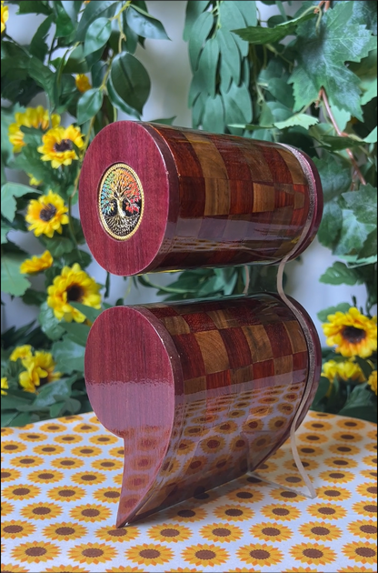 A video of a wooden semicolon shaped box with a checkered pattern on a floral tablecloth with sunflowers and greenery in the background.